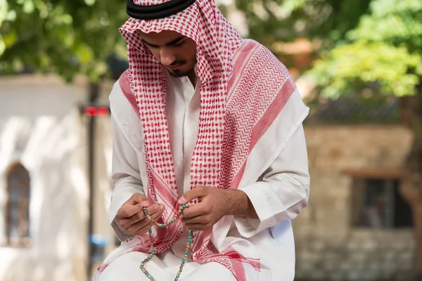 Close-up van mannelijke handen bidden met rozenkrans — Stockfoto