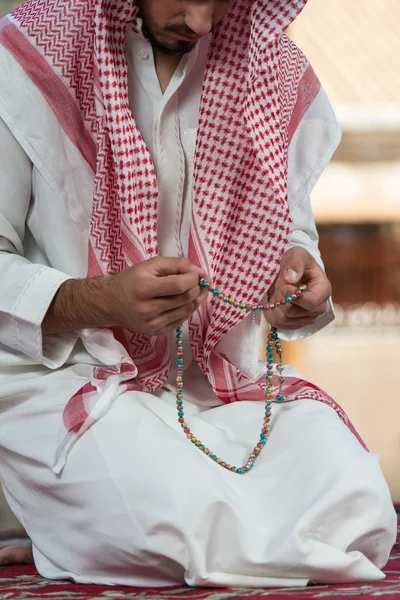 Nahaufnahme männlicher Hände, die mit Rosenkranz beten — Stockfoto