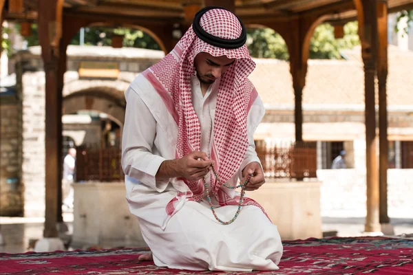 ロザリオで祈る男性の手のクローズアップ — ストック写真