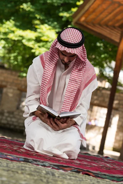 Muslim Man In Dishdasha Is Reading The Quran — Stock Photo, Image