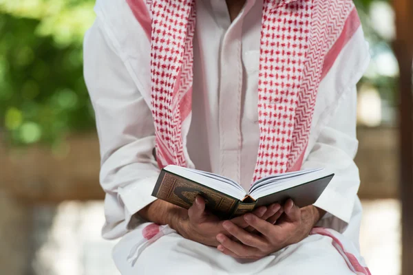 Muslim Man In Dishdasha Is Reading The Quran — Stock Photo, Image