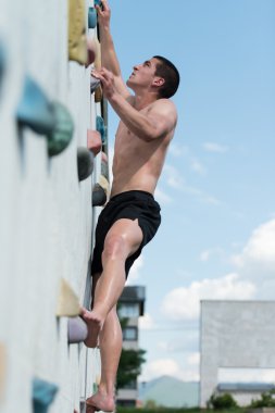 Genç adam duvarlara tırmanıyor.