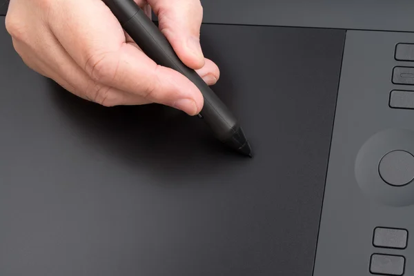 Hand som håller grafisk penna över bordet — Stockfoto