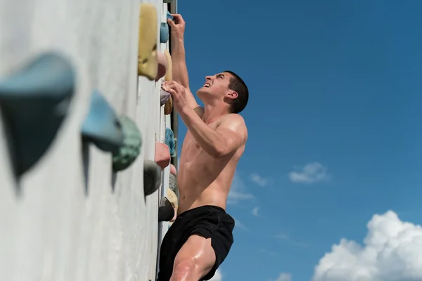 Jongeman klimmende muur rots buiten — Stockfoto