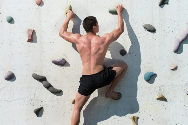 Lutando para alcançar o aperto de mão na parede de escalada — Fotografia de Stock