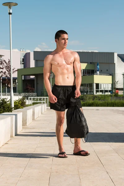 Hombre serio de pie al aire libre y músculos flexionantes —  Fotos de Stock