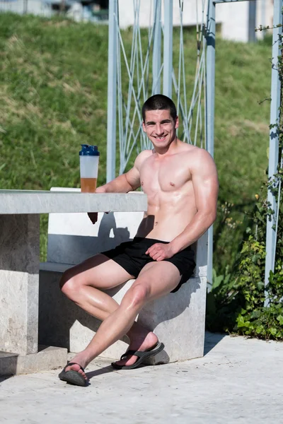 Giovane uomo muscolare che beve una bottiglia d'acqua — Foto Stock