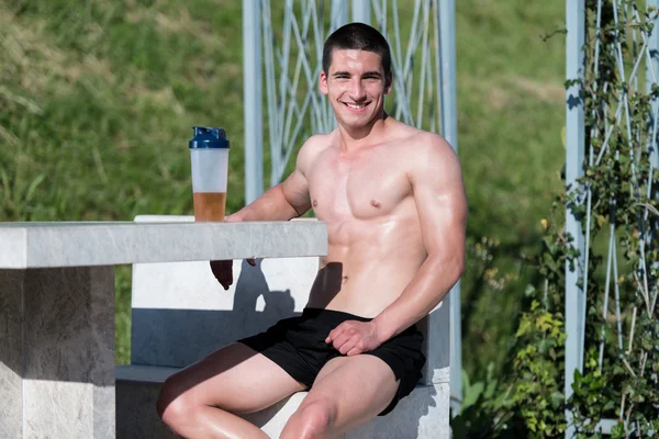 Giovane uomo muscolare che beve una bottiglia d'acqua — Foto Stock