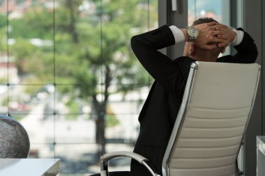 Ellerini başının arkasına ile rahatlatıcı işadamı