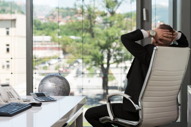 Genç adam ofiste bilgisayarla çalışıyor.