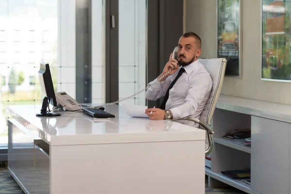 Empresario hablando por teléfono y usando computadora — Foto de Stock