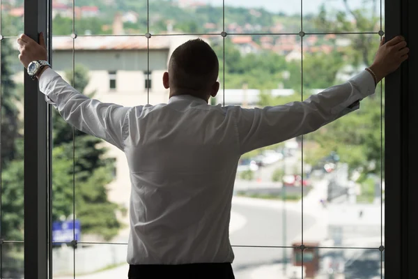 Businessman Looking Through Office Window — Stock Photo, Image