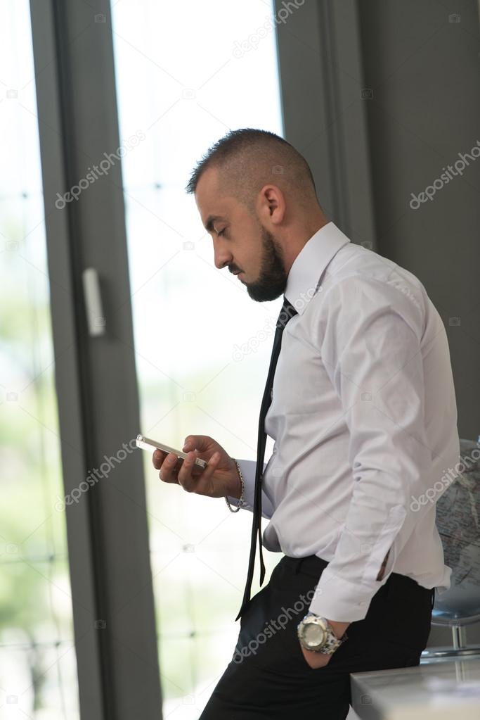 Business Man Texting On Cellphone In Modern Office