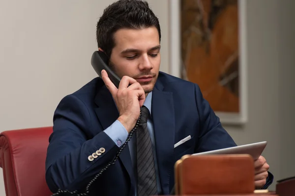 Manier inzakenman praten op telefoon in office — Stockfoto