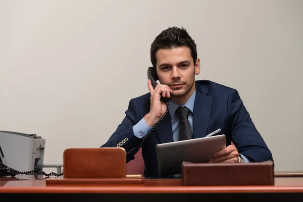 Telefonla konuşurken ve bilgisayar kullanarak iş adamı — Stok fotoğraf