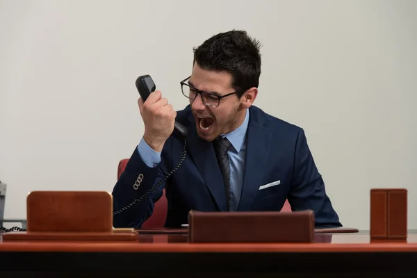 Wütender Geschäftsmann brüllt in ein Handy — Stockfoto