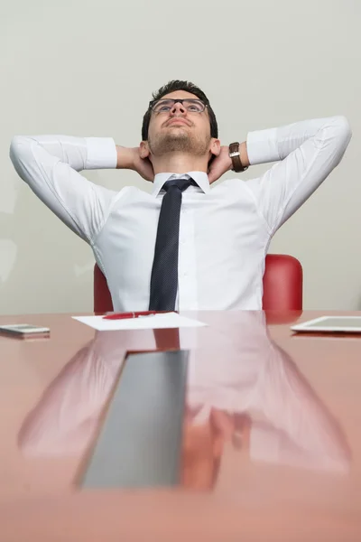 Jovem empresário relaxa sentado no escritório — Fotografia de Stock