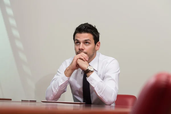 Hombre de negocios sobrecargado sentado junto a su escritorio — Foto de Stock