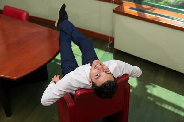Бизнесмен отдыхает на офисном стуле — стоковое фото