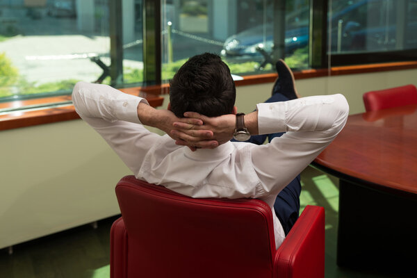 Young Businessman Relaxes Sitting In The Office