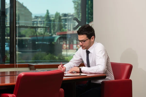 Porträt eines attraktiven Geschäftsmannes, der Zeitung im Büro liest — Stockfoto