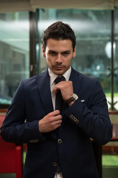 Young Businessman Correcting A Tie — Stock Photo, Image