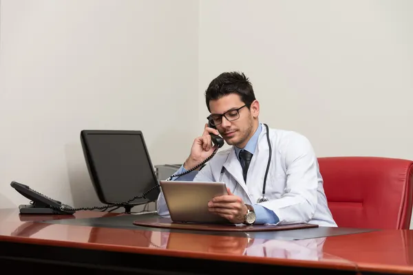 Läkare pratar på telefon i office — Stockfoto