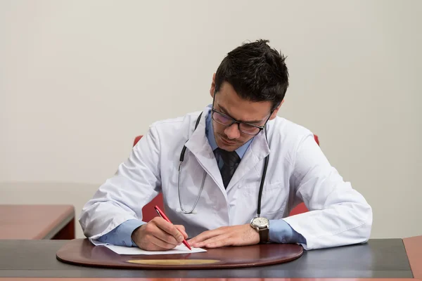 Doctor Sitting At Office Desk Signing A Contract — Stock Photo, Image