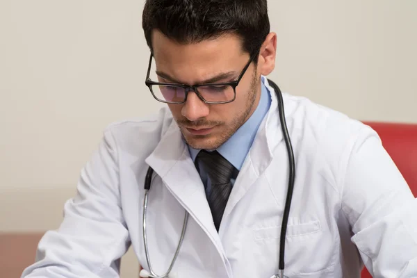 Doctor Sitting At Office Desk Signing A Contract — Stock Photo, Image