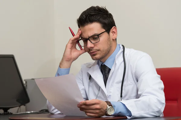 Портрет привлекательного врача, читающего бумагу в офисе — стоковое фото
