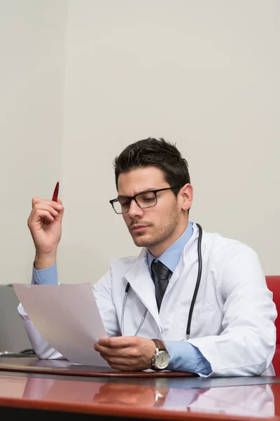 Junge Ärztin im Büro schaut auf Papier — Stockfoto