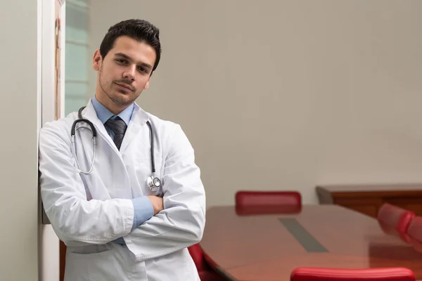 Portret van jonge dokter staande armen gekruist — Stockfoto