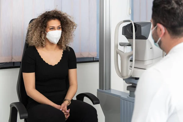 Männlicher Augenarzt Hört Sorgfältig Junge Frau Trägt Chirurgische Medizinische Maske — Stockfoto