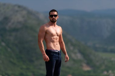 Yakışıklı Sakallı Adam Güçlü Duruyor ve Dışarıda Poz Veriyor - Dağ Arkaplanı