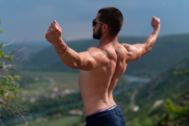 Yakışıklı Sakallı Adam Güçlü Duruyor ve Dışarıda Poz Veriyor - Dağ Arkaplanı