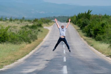 Sokak Otobanı 'nda zıplayan ve dışarıda eğlenen yakışıklı adam. 