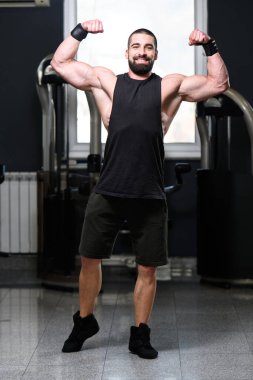 İyi eğitilmiş vücudunu gösteren genç bir adamın portresi - kaslı atletik vücut geliştirici spor sonrası vücut geliştirme modelliği pozu