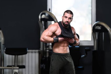 Yakışıklı Genç Adam Spor Salonunda Güçlü Duruyor ve Kaslarını Geriyor - Kas Atletik Vücut Geliştirici Spor Sonrası Spor Pozisyonu