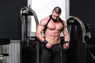 İyi eğitilmiş vücudunu gösteren genç bir adamın portresi - kaslı atletik vücut geliştirici spor sonrası vücut geliştirme modelliği pozu