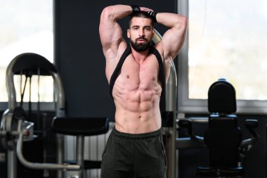 İyi eğitilmiş vücudunu gösteren genç bir adamın portresi - kaslı atletik vücut geliştirici spor sonrası vücut geliştirme modelliği pozu