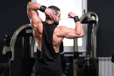 İyi eğitilmiş vücudunu gösteren genç bir adamın portresi - kaslı atletik vücut geliştirici spor sonrası vücut geliştirme modelliği pozu