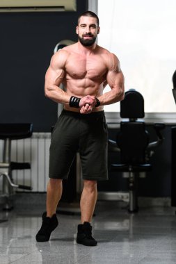 İyi eğitilmiş vücudunu gösteren genç bir adamın portresi - kaslı atletik vücut geliştirici spor sonrası vücut geliştirme modelliği pozu