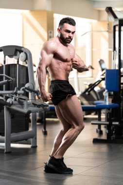 İyi eğitilmiş vücudunu gösteren genç bir adamın portresi - kaslı atletik vücut geliştirici spor sonrası vücut geliştirme modelliği pozu