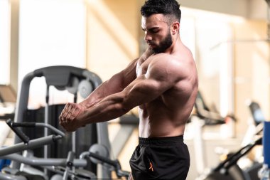 İyi eğitilmiş vücudunu gösteren genç bir adamın portresi - kaslı atletik vücut geliştirici spor sonrası vücut geliştirme modelliği pozu