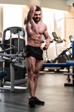 İyi eğitilmiş vücudunu gösteren genç bir adamın portresi - kaslı atletik vücut geliştirici spor sonrası vücut geliştirme modelliği pozu