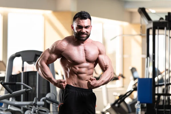 Yakışıklı Genç Adam Spor Salonunda Güçlü Duruyor Kaslarını Geriyor Kas — Stok fotoğraf