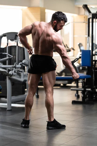 健全な若い男立っているジムと屈曲の筋肉で強い筋肉運動ボディービルダー フィットネス モデルの練習後のポーズ — ストック写真