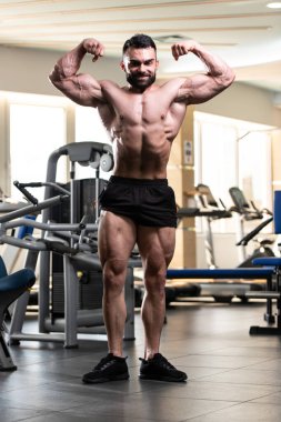 Spor Salonunda Güçlü Duran Genç Adam - Kas Atletik Vücut Geliştirici Spor Sonrası Spor Pozisyonu