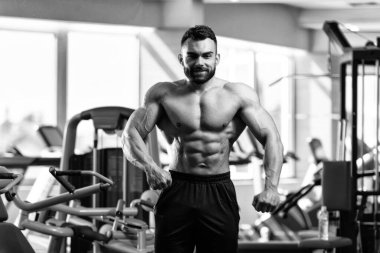 İyi eğitilmiş vücudunu gösteren genç bir adamın portresi - kaslı atletik vücut geliştirici spor sonrası vücut geliştirme modelliği pozu