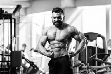 Yakışıklı Genç Adam Spor Salonunda Güçlü Duruyor ve Kaslarını Geriyor - Kas Atletik Vücut Geliştirici Spor Sonrası Spor Pozisyonu